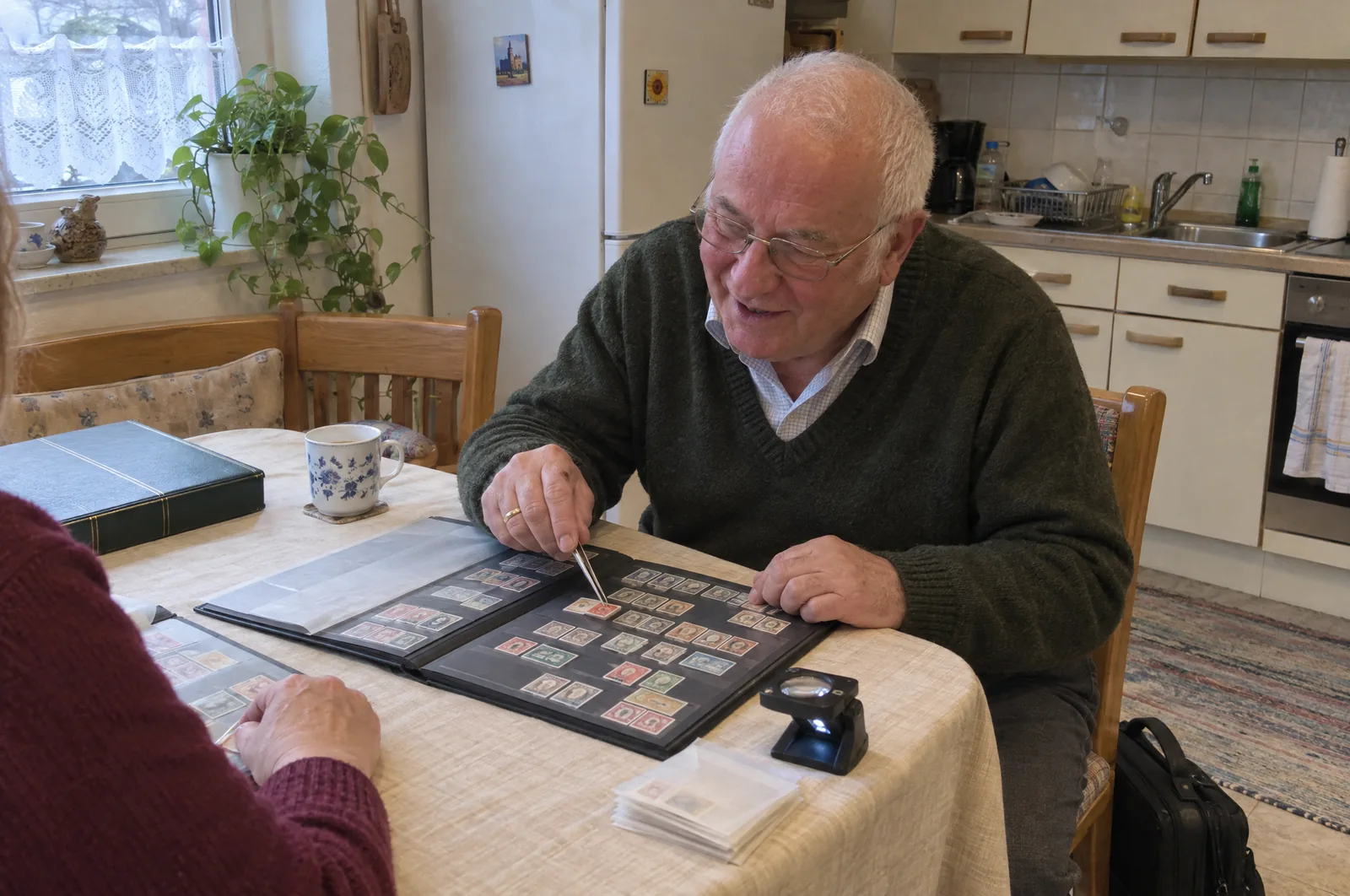 Werner Klöpsch bei einer Briefmarkenbewertung am Esstisch einer Kundin